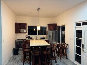 a kitchen with wooden cabinets and a table and chairs at Rancho El Valle in Acajutla