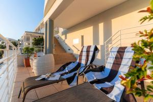 a patio with two chairs and a table on a balcony at Sunset Azure Studio - Pool Views 2 min to beach in Cape Town