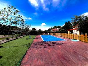a swimming pool in a yard with a green lawn at Casa de campo in Illana +8 photos