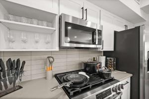 a kitchen with a stove with pots and pans at Stylish SLC Townhome King 2-Car Garage in Salt Lake City +34 photos