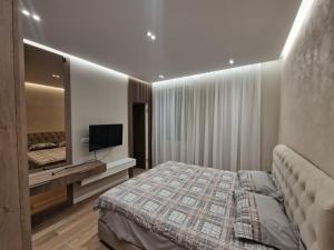 een slaapkamer met een bed en een televisie. bij Nostra Casa - Tivat in Tivat