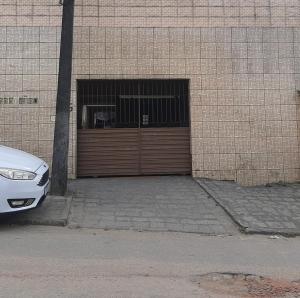 a white car parked in front of a garage at casa proximo do ceaga in Garanhuns