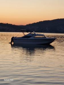 ein kleines Boot, das bei Sonnenuntergang im Wasser sitzt in der Unterkunft Camping Principata 