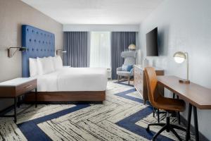 a hotel room with a bed and a desk at Four Points by Sheraton College Park Atlanta Airport in Atlanta