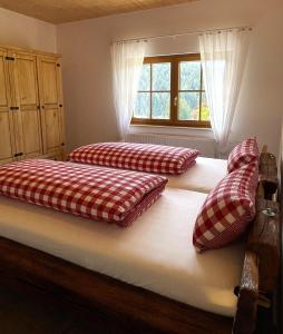 Dos camas con almohadas en un dormitorio. en Felsenhof Simonswald, en Simonswald