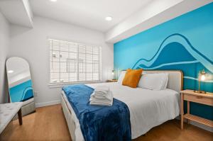 a bedroom with a blue accent wall and a bed at SLC Townhome 2BR Mountain Views Garage in Salt Lake City