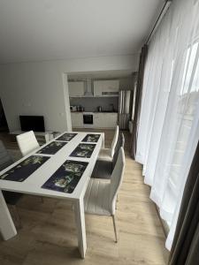 - une table et des chaises blanches dans la chambre dans l'établissement Florina namai, à Marijampolė