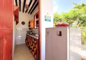 eine Küche mit einem Kühlschrank und einer Theke in der Unterkunft Cozy Bungalow - Garden, Terrace, Rooftop, Beach in Bwejuu + 32 Fotos
