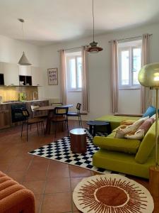 Una sala de estar con un sofá verde y una cocina. en Acquasparta Piazza, en Acquasparta