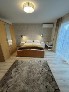 a bedroom with a large bed and a large window at Florina namai in Marijampolė