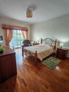 Un dormitorio con una cama y suelo de madera. en Casa Jugueiros, en Viseu