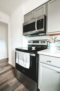 a kitchen with a black stove and a microwave at Bay Breeze Retreat in Morehead City