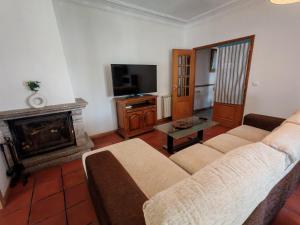 a living room with a couch and a fireplace at Casa Jugueiros in Viseu +20 photos