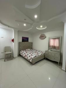 a bedroom with a bed and a table and a chair at Lindo Apartamento suite country club villas in Santa Rosa