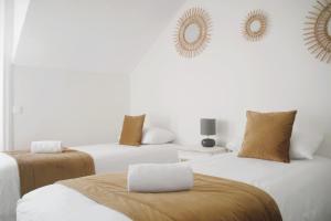 two beds in a white room with mirrors on the wall at Hotel Ker Lehn - La Plage in Piriac-sur-Mer