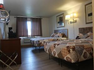 ein Hotelzimmer mit zwei Betten und einem Fenster in der Unterkunft Cyclone Lodge in Harlan