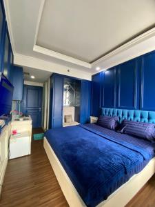 ein blaues Schlafzimmer mit einem großen Bett und einem TV in der Unterkunft Vinsroom Dua in Seturan