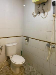 ein Badezimmer mit Toilette und Dusche in der Unterkunft Vinsroom Dua in Seturan
