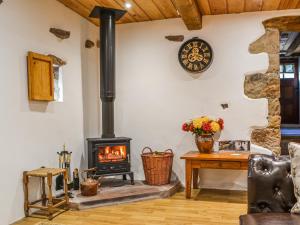 einen Kamin im Wohnzimmer mit Herd in der Unterkunft The Bothy - Cottage in Dearham