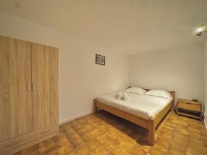 una camera da letto con un letto e un armadio in legno di Les Hauts de Bezouce, Vue, Piscine & Calme a Bezouce Altre 21 foto