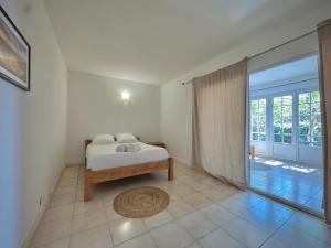 una camera da letto con un letto e una porta scorrevole in vetro di Les Hauts de Bezouce, Vue, Piscine & Calme a Bezouce