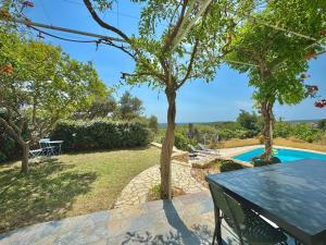un giardino con tavolo e piscina di Les Hauts de Bezouce, Vue, Piscine & Calme a Bezouce