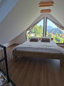 a large bed in a room with a large window at En hribček in Ptujska Gora