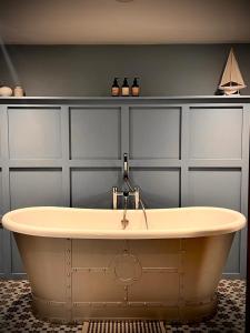 een badkamer met een bad en een muur bij The Bath Arms Shearwater in Warminster +36 foto's
