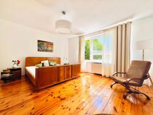 a bedroom with a bed and a chair and a window at Dom Verte z ogrodem na Jurze in Turów Celiny