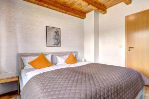 a bedroom with a large bed with orange pillows at Ferienhaus Odin in Bansin +17 photos