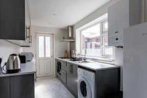 una cocina con lavadora y secadora junto a una ventana en Central Darlington 3 Bedroom Home, en Darlington 41 fotos más
