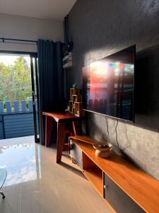 a living room with a flat screen tv on a wall at Villa Nizzy in Ban Mae Nam