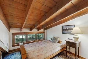a bedroom with a bed and a wooden ceiling at Emmon's Mittersill Village Chalet in Franconia
