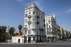 a tall white building on the corner of a street at AmazINN Places Casa Calabuig Ático Marina Real - No Ascensor- in Valencia