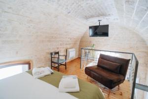 a bedroom with a bed and a chair at Bue Marino Suites - Exclusive stay with Castle view in Bisceglie