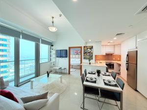 una cucina e un soggiorno con un tavolo di Ocean Heights New 2BDR with full Sea & Dubai Eye view in Marina by CEG Group a Dubai