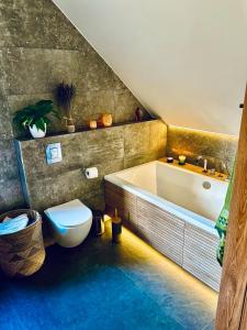 a bathroom with a toilet and a bath tub at chata z widokiem in Grzmiąca +16 photos