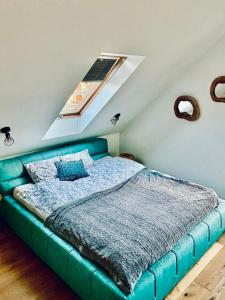 a green bed in a room with a window at chata z widokiem in Grzmiąca