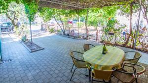 a table with chairs and a bottle of wine on it at Apartment La Vie in Mostar