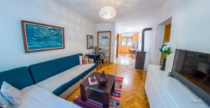 a living room with a blue couch and a television at Apartment La Vie in Mostar