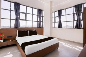 a bedroom with a large bed with windows at Hotel S Boss in Waluj Buzurg