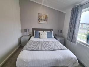 a bedroom with a large bed with two night stands at Cherry Blossom 48 Hot Tub in Garton