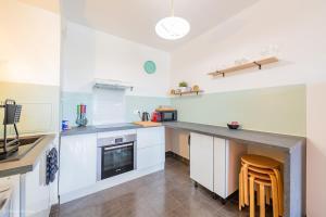 a kitchen with white cabinets and a counter top at Le Rangiroa, 4 people, 5 min to Disneyland Paris in Marne-la-Vallée
