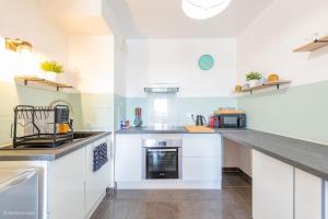 a kitchen with white cabinets and a counter top at Le Rangiroa, 4 people, 5 min to Disneyland Paris in Marne-la-Vallée