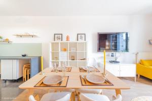 a dining room table with white chairs and a yellow couch at Le Rangiroa, 4 people, 5 min to Disneyland Paris in Marne-la-Vallée +22 photos