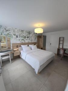 Thun-Saint-MartinにあるLa maison du Moulinの大きな白いベッドと机のある寝室