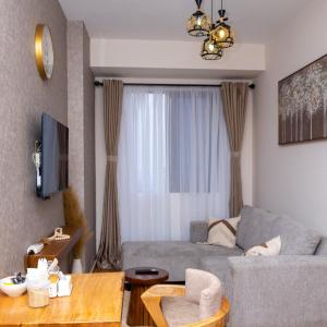 SkyView Haven by Seluveto Homes في نيروبي: غرفة معيشة مع أريكة وطاولة