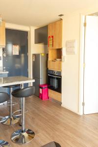 a kitchen with a refrigerator and a table and chairs at Nuevo Depto 3 camas, vista al estadio y estacionamiento gratis in Concepción
