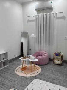 a living room with a pink couch and a table at Méow Homestays in Ðoan Xá
