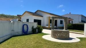 una casa blanca con una valla y un patio en Chloe's Beach House, en A dos Cunhados
